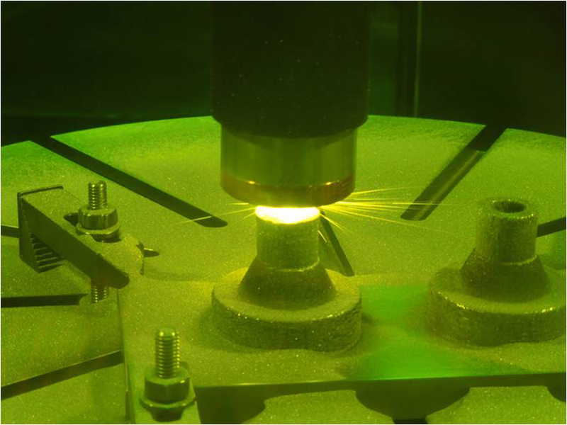 Scientists make a rocket nozzle using a new 3-D printing technique that allows for multiple metallic properties in the same object. This technique involves blowing multiple metal powders into a laser beam, so that the laser melts the powder and forms a small pool at the point where the laser touches the part that is being built. Courtesy of Nasa JPL/CalTech.