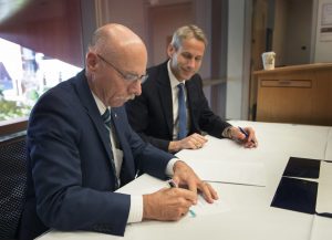 Keoki Jackson, Chief Technical Officer for Lockheed Martin, looks on as Penn State's vice-president for research Neil Sharkey signs the master research agreement, creating a partnership between Penn State research and the global security and aerospace company.