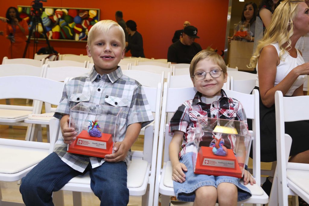 Left: Two of the first pediatric heart surgery patients: healthy, happy and showing off their own surgical-planning 3D-printed heart models. Right: A patient-specific pediatric heart model, 3D-printed in full color. (Images courtesy Phoenix Children’s Hospital)