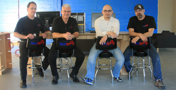 Sitting on TechShop-branded swivel chairs, with HP Z600 workstations in the back. The upstairs space will be a communal meeting room and brainstorming environment for TechShop members.