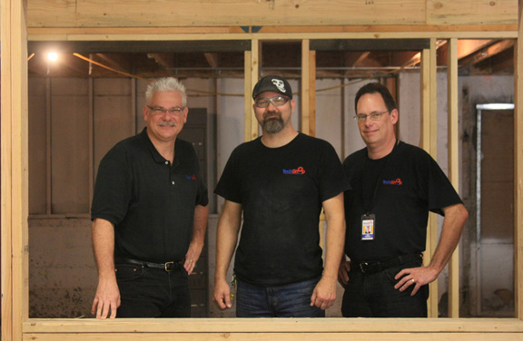 TechShop team, framed in a window of their new San Francisco location. Left to right: Mark Hatch, CEO; Jim Newton, founder; Joe XXX.