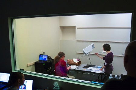 Fig. 5. Ximedica team members (foreground) pay close attention to user research on the functionality of the robotic arm portion of the SPORT Surgical System during mock gallbladder surgery.