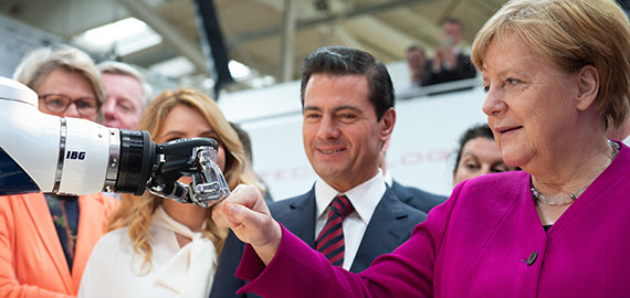 German Federal Chancellor Angela Merkel and Mexican President Peña Nieto opened Hannover Messe by meeting a prototype home assistant robot built by automation specialist Kuka. The robot, named “i-do,” carried coffee and took photos of the two leaders. Merkel and Nieto passed on offering the robot formal handshakes, choosing instead to share a fist-bump with i-do. (Source: Hannover Messe)