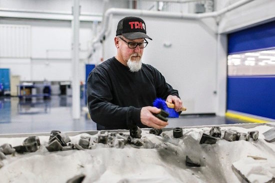 A technician cleans sand casted molds at Ford's Advanced Manuafcturing Center. Image courtesy of Ford.